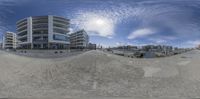 a fish eye view is of two buildings near a dock with boats in the water