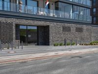 a black colored brick building with many balconies and windows is the entrance to this very urban complex