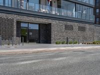 a black colored brick building with many balconies and windows is the entrance to this very urban complex