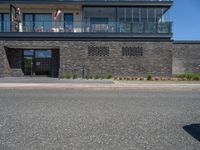 an urban building with some brick walled in area outside a fence and windows and balcony