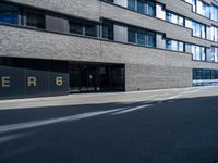 a empty street lined with tall black buildings on both sides of it and a sign that reads per 6