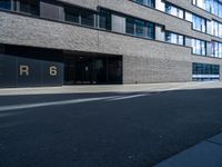 a empty street lined with tall black buildings on both sides of it and a sign that reads per 6