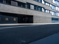 a empty street lined with tall black buildings on both sides of it and a sign that reads per 6