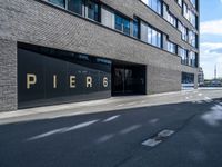 a empty street lined with tall black buildings on both sides of it and a sign that reads per 6