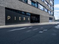 a empty street lined with tall black buildings on both sides of it and a sign that reads per 6