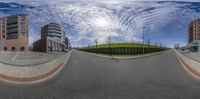 an image of a distorted fisheye lens showing some buildings on the street and a park