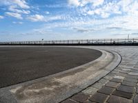 a concrete curb with a street corner next to it and sky in the background and on the ground there is a long exposure