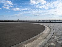 a concrete curb with a street corner next to it and sky in the background and on the ground there is a long exposure