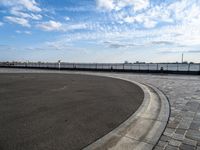 a concrete curb with a street corner next to it and sky in the background and on the ground there is a long exposure