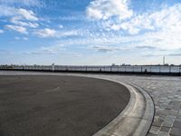 a concrete curb with a street corner next to it and sky in the background and on the ground there is a long exposure