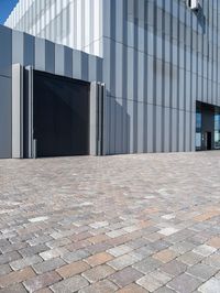 an industrial building that has gray metal siding on it's exterior and has a parking space outside