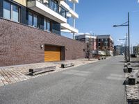 brick side walk and sidewalk in front of a large building with brown trim and two wooden steps