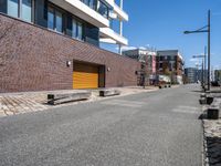 brick side walk and sidewalk in front of a large building with brown trim and two wooden steps