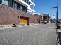 brick side walk and sidewalk in front of a large building with brown trim and two wooden steps