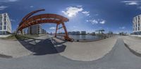 a 360 view of a bridge and buildings on the water side, from underneath, over looking a city