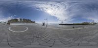 the panorama lens shows a man riding on skateboard at an intersection of a city plaza