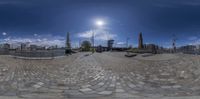 a fisheye lens of an old town in europe with many people walking around it