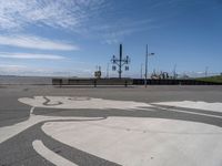 the sidewalk is paved with a circular pattern that can be seen in the distance as two people cross the street