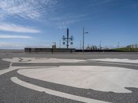 the sidewalk is paved with a circular pattern that can be seen in the distance as two people cross the street