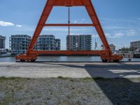 two cranes with a flat area for loading passengers at a train station with other cars behind them