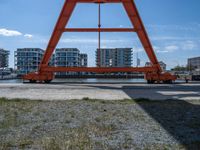 two cranes with a flat area for loading passengers at a train station with other cars behind them