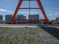 two cranes with a flat area for loading passengers at a train station with other cars behind them