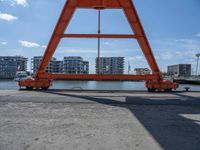 two cranes with a flat area for loading passengers at a train station with other cars behind them