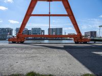 two cranes with a flat area for loading passengers at a train station with other cars behind them