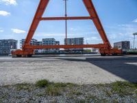 two cranes with a flat area for loading passengers at a train station with other cars behind them