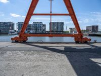 two cranes with a flat area for loading passengers at a train station with other cars behind them