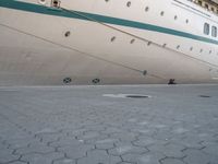 the rear end of a ship is docked next to concrete paving in front of it