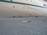 the rear end of a ship is docked next to concrete paving in front of it