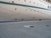 the rear end of a ship is docked next to concrete paving in front of it