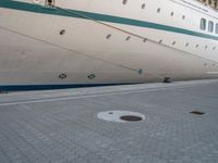 the rear end of a ship is docked next to concrete paving in front of it