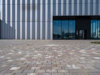 brick path and building with modern glass front door area, which is reflected by glass doors