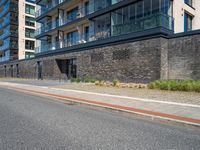 a brick and stone building along the side of the street near cars with people looking out on windows