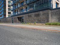 a brick and stone building along the side of the street near cars with people looking out on windows