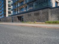 a brick and stone building along the side of the street near cars with people looking out on windows