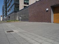 a person riding a skateboard along the sidewalk in front of a building with large windows