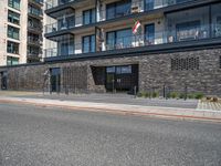 street with concrete side and black buildings on the side and an open area to the ground