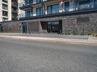 street with concrete side and black buildings on the side and an open area to the ground