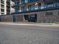 street with concrete side and black buildings on the side and an open area to the ground