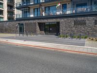 street with concrete side and black buildings on the side and an open area to the ground