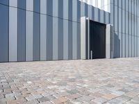 a building with two large doors and bricks on the ground in front of it,