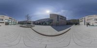 two cameras are reflecting the sun in this city square area of a university campus's courtyard