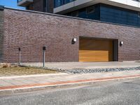 a building is shown with a brick facade and driveway side walk, and an external brown garage door