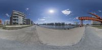 the skate park and the beach under a clear blue sky with clouds in it with a fisheye lens