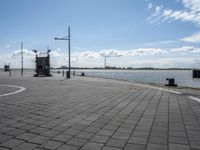 a square stone pavement with a car park in the background on an empty runway with buildings in front