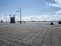 a square stone pavement with a car park in the background on an empty runway with buildings in front