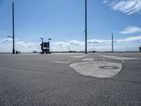 a drawing on asphalt in an airport parking lot with power poles and street lamps in the background